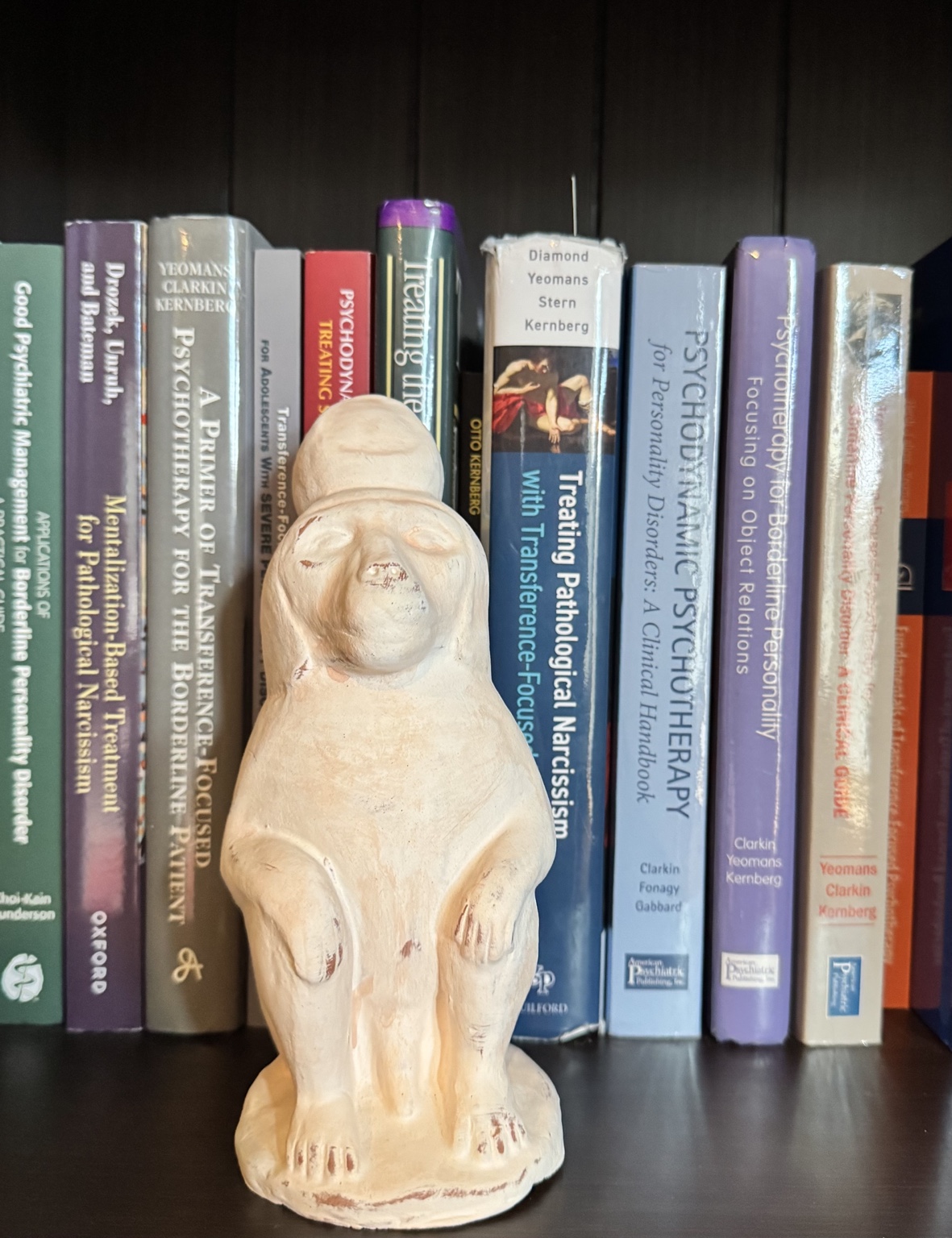TFP books on a bookshelf with sculpture